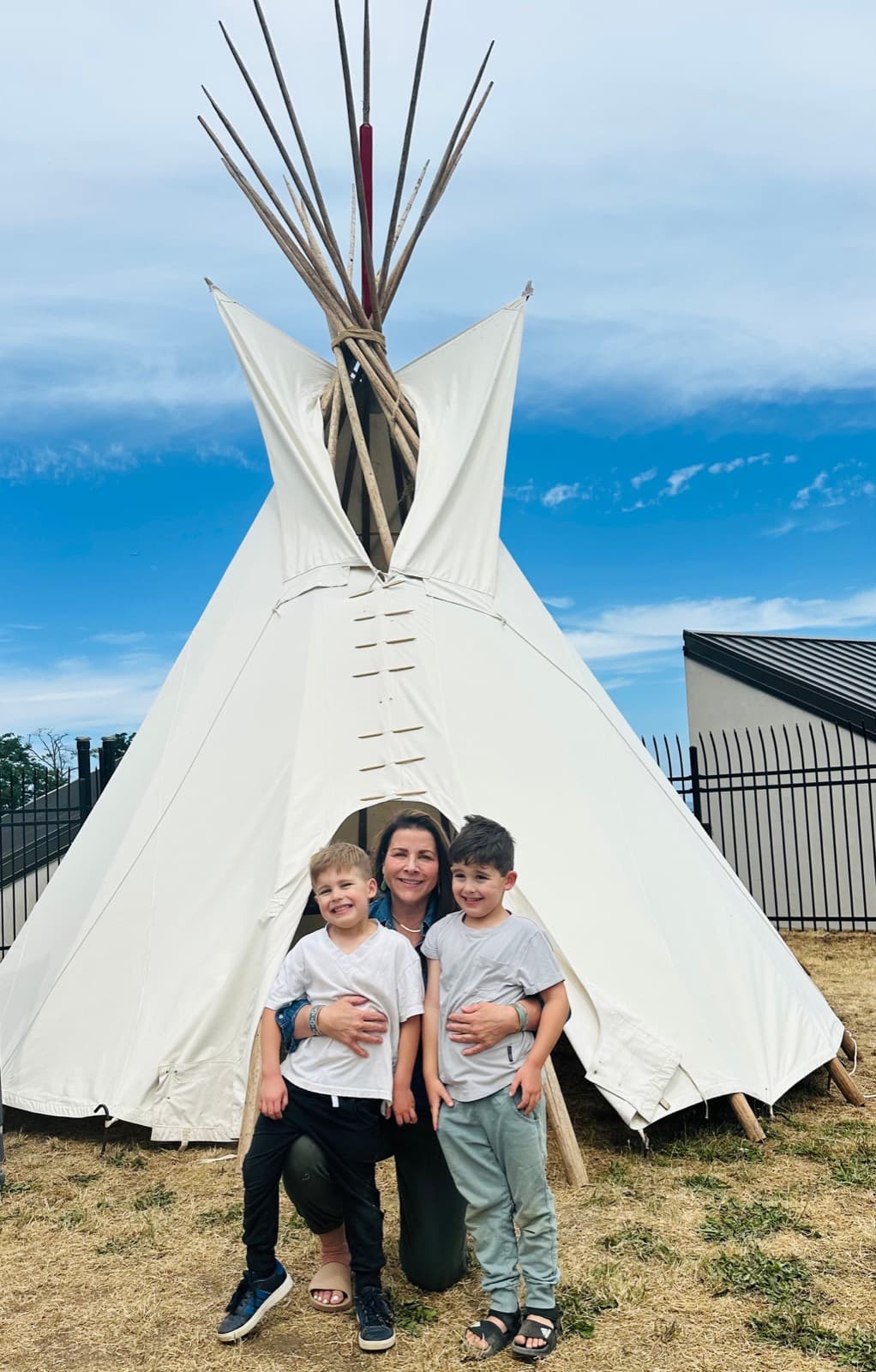 Three generations of the family together outside a teepee.